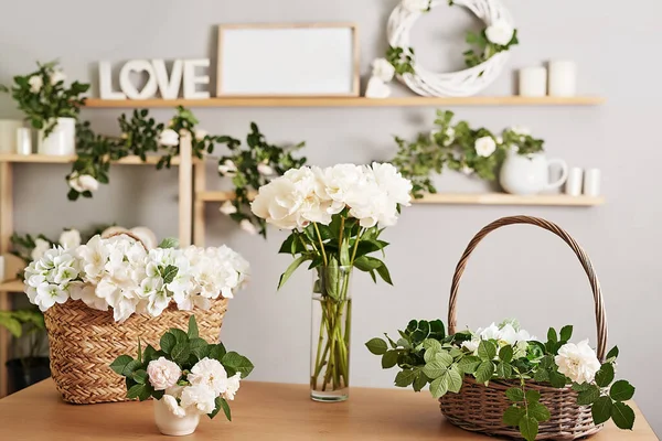 Floral background. Flower shop interior. Floral design studio, making decorations and arrangements. Flowers delivery service and sale of home plant, creating order. Peonies and roses
