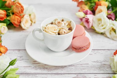 Gül buketi, Eustomas ve ortancalar masanın üstünde. Bir fincan çay, kahve ve kurabiye. Anneler günü için tebrik kartı. Samimi günaydın. Doğum günün kutlu olsun. Romantik kahvaltı. Valentine için Kompozisyon.