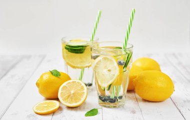 Dilimlenmiş limon, salatalık ve yabanmersinli detoks suyu. Diyet sağlıklı beslenme ve kilo kaybı. Buz gibi yaz kokteyli ya da cam mason kavanozunda limonata. Sağlık, zindelik, sağlıklı beslenme.