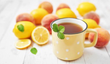 Beyaz arka planda meyve limonları ve şeftaliler. Yaz kartpostalı. Merhaba yaz! Hasat. Sağlıklı gıda ve beslenme. Meyve arkaplanı. Sıcak bir kahvaltı. Doğal organik ürünler. Vitaminler