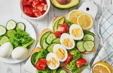 Kahvaltıda tahıllı sandviç, abur cubur avokado, yumurta, domates, salatalık. Keto diyeti. Sağlıklı beslenme, diyet, vejetaryen vejetaryen, temizlik. Lezzetli kahvaltı ya da öğle yemeği.