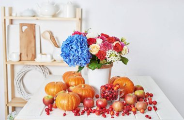 Sonbahar hasat balkabağı arka planı. Balkabakları, elmalar ve çiçekler masada. Şükran Günü masası. Uzayı kopyala Cadılar Bayramı ya da mevsimsel sonbahar. Tasarım modeli. Tebrik kartı. Sonbahar mutfağı