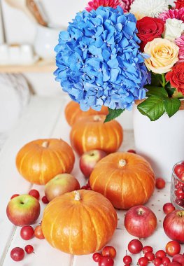 Sonbahar hasat balkabağı arka planı. Balkabakları, elmalar ve çiçekler masada. Şükran Günü masası. Uzayı kopyala Cadılar Bayramı ya da mevsimsel sonbahar. Tasarım modeli. Tebrik kartı. Sonbahar mutfağı