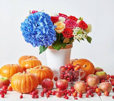 Sonbahar hasat balkabağı arka planı. Balkabakları, elmalar ve çiçekler masada. Şükran Günü masası. Uzayı kopyala Cadılar Bayramı ya da mevsimsel sonbahar. Tasarım modeli. Tebrik kartı. Sonbahar mutfağı