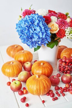 Sonbahar hasat balkabağı arka planı. Balkabakları, elmalar ve çiçekler masada. Şükran Günü masası. Uzayı kopyala Cadılar Bayramı ya da mevsimsel sonbahar. Tasarım modeli. Tebrik kartı. Sonbahar mutfağı