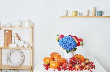 Sonbahar hasat balkabağı arka planı. Balkabakları, elmalar ve çiçekler masada. Şükran Günü masası. Uzayı kopyala Cadılar Bayramı ya da mevsimsel sonbahar. Tasarım modeli. Tebrik kartı. Sonbahar mutfağı