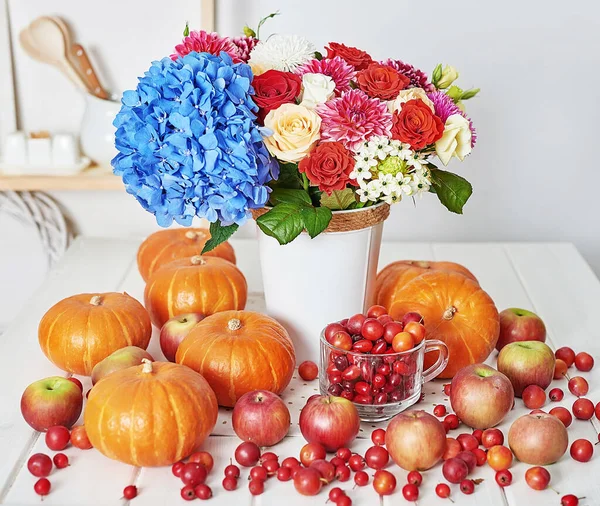 Sonbahar hasat balkabağı arka planı. Balkabakları, elmalar ve çiçekler masada. Şükran Günü masası. Uzayı kopyala Cadılar Bayramı ya da mevsimsel sonbahar. Tasarım modeli. Tebrik kartı. Sonbahar mutfağı