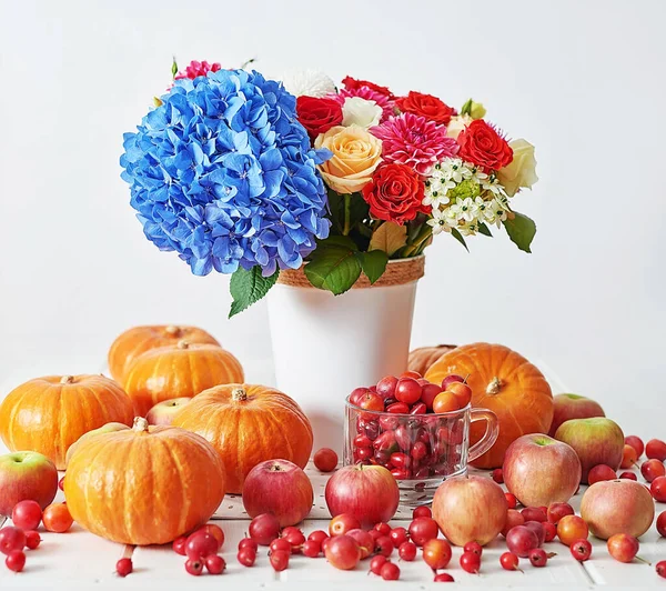 Sonbahar hasat balkabağı arka planı. Balkabakları, elmalar ve çiçekler masada. Şükran Günü masası. Uzayı kopyala Cadılar Bayramı ya da mevsimsel sonbahar. Tasarım modeli. Tebrik kartı. Sonbahar mutfağı