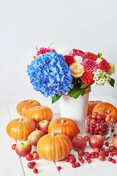 Sonbahar hasat balkabağı arka planı. Balkabakları, elmalar ve çiçekler masada. Şükran Günü masası. Uzayı kopyala Cadılar Bayramı ya da mevsimsel sonbahar. Tasarım modeli. Tebrik kartı. Sonbahar mutfağı