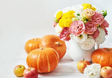 Sonbahar hasat balkabağı arka planı. Balkabakları, elmalar ve çiçekler masada. Şükran Günü masası. Uzayı kopyala Cadılar Bayramı ya da mevsimsel sonbahar. Tasarım modeli. Tebrik kartı. Sonbahar mutfağı