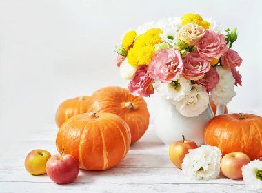 Sonbahar hasat balkabağı arka planı. Balkabakları, elmalar ve çiçekler masada. Şükran Günü masası. Uzayı kopyala Cadılar Bayramı ya da mevsimsel sonbahar. Tasarım modeli. Tebrik kartı. Sonbahar mutfağı