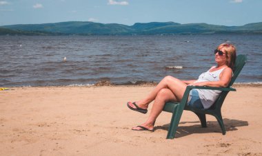 sahilde Maskinonge Gölü St-Gabriel-de-Brandon Quebec Kanada oturan tatilde emekli kadın