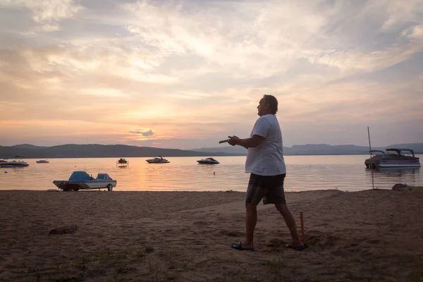 成人男性の夕暮れホースシュー ゲーム ビーチ活動 カナダを投げる — ストック写真