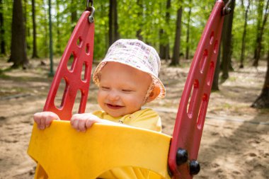 oyun alanında salıncakta sevimli sarışın kafkas bebek