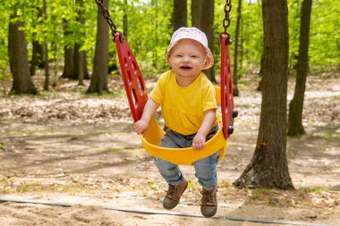 oyun alanında salıncakta sevimli sarışın kafkas bebek