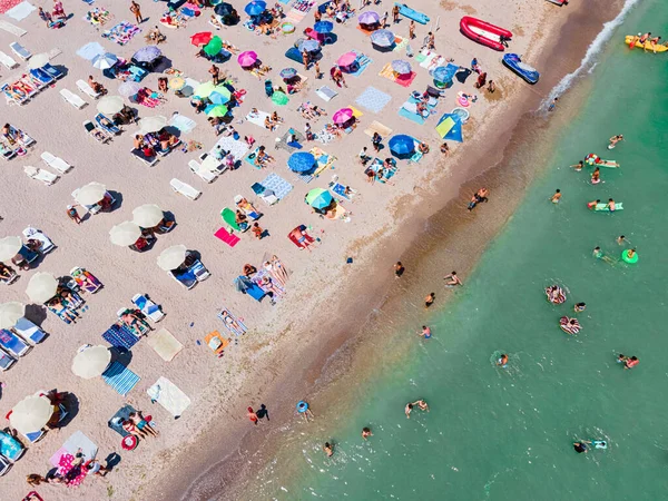 夏のオーシャンシーサイドビーチの人々とカラフルな傘の空中ビュー — ストック写真