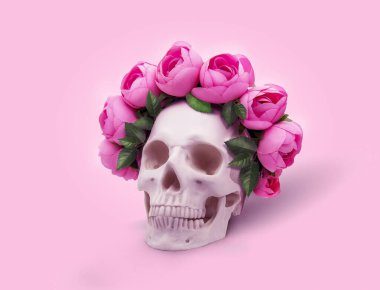Pembe arka planda gül çelengi olan bir kafatası.