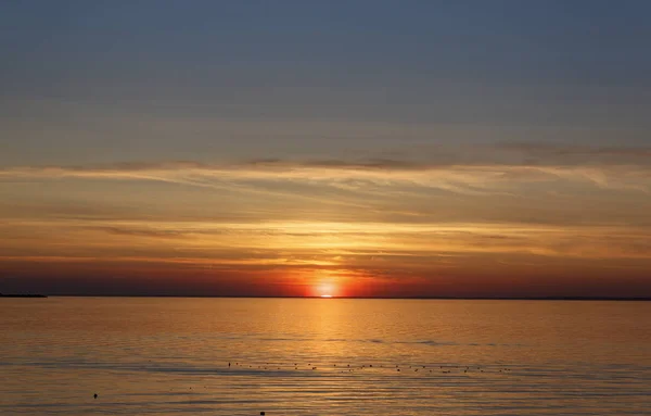 Wunderschöner Sonnenuntergang über dem Meer. die Sonne geht über dem Wasser unter. Der Himmel ist mit leuchtenden Farben bemalt. Sonnenuntergang Strand an einem Sommerabend. Finnischer Golf, Ostsee, Kronstadt, Sankt-Peterburg, Russland. — Stockfoto