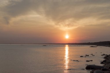 Deniz üzerinde manzara günbatımı. Güneşin suda yansıması. Gökyüzü parlak renklerle boyanmıştır. Yaz akşamı günbatımı Plajı. Finlandiya Körfezi, Baltık Denizi, Komarovo, Sankt-Petersburg, Rusya.