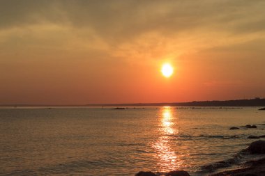 Deniz üzerinde manzara günbatımı. Güneşin suda yansıması. Gökyüzü parlak renklerle boyanmıştır. Yaz akşamı günbatımı Plajı. Finlandiya Körfezi, Baltık Denizi, Komarovo, Sankt-Petersburg, Rusya.