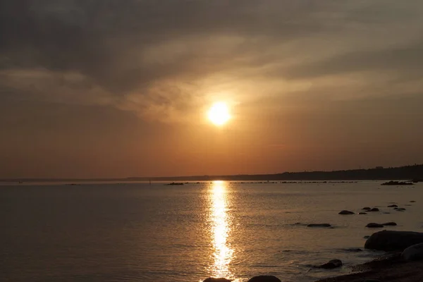 Malowniczy zachód słońca nad morzem. Odbicie słońca w wodzie. Niebo jest malowane jasnymi kolorami. Sunset Beach w letni wieczór. Zatoka fińska, Morze Bałtyckie, Komarovo, Sankt-Petersburg, Rosja. — Zdjęcie stockowe