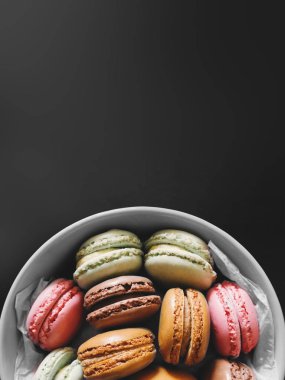 Fransız tatlı macarons siyah arka plan ile plaka üzerinde