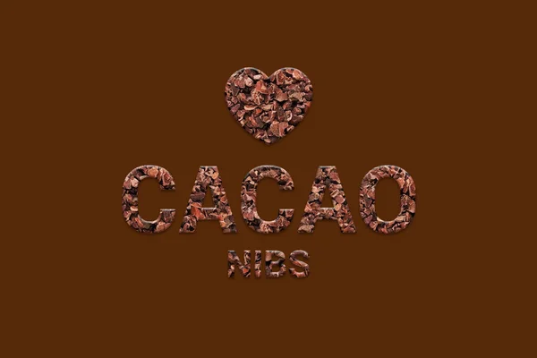 Cacao nibs texture text with heart shape on dark brown background. Typography of raw organic food beans. Vegan, Super food and detox food.