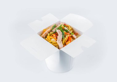 Domuz eti filetosu, sebze, soya sosu ve taze soğan soğanı ile birlikte beyaz karton paket servis kutusunda yalıtılmış Asya Ramen Eriştesi. Yemek paketi ve içinde yemek hazır.