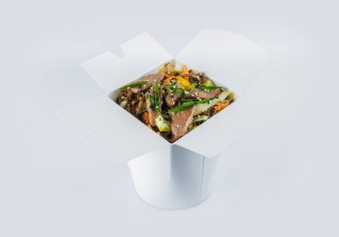 Biftek fileto, sebze, soya sosu ve taze soğanlı soğan soğanlı karabuğday köftesi beyaz karton paket kutusunda. Yemek paketi ve içinde yemek hazır.