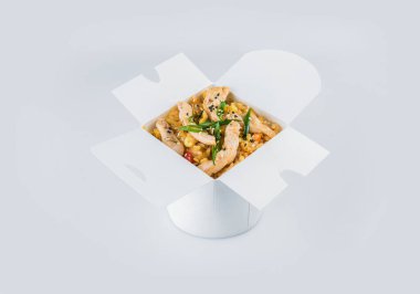 Isolated Chinese rice with chicken fillet, vegetables, soy sauce and spring onion scallions in white carton takeaway delivery box. Food delivery background image. Asian rice ready to eat vegan dish clipart