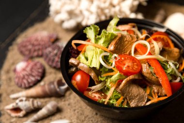 İki Japon suşisi, deniz kabukları ve yıldızlarla kumlu arka planda paket servis kutusunda. Somon ve yılan balıklı Asya dürümleri. Philadelphia peyniri, salatalık ve avokado..