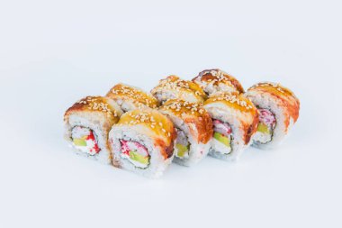 Avokadolu Asya suşisi, yengeç çubuğu (yengeç eti), uçan balık yumurtası (tobiko havyar) ve Norveç yosununa sarılmış Philadelphia krem peyniri ve üstünde yılan balığı ile pilav. Japon yemeği gri renkte izole edildi