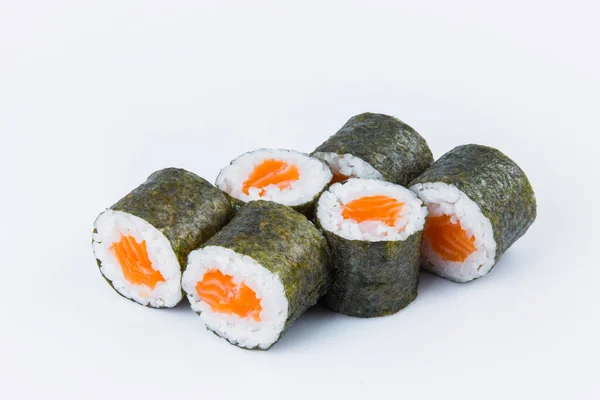 Japon Sake Maki Roll 'un yanına somon balığı ve Norveç yosununa sarılmış pilav. Gri arka planda izole edilmiş Asya geleneksel yemeklerinin yakın çekimi. İzolasyon menüsü resmi