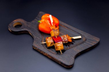 Japon tavuk şişi ve dolmalık biberin yan görüntüsü. Ahşap tahtada Yakitori Tavuğu ve arka planda sebze. Pan Asya izole yemeği.