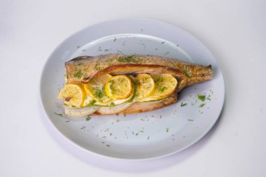 Limon dilimli fırında uskumru ve gri zemin üzerinde soğan. Taze dereotuyla servis edilen ızgara balık. Yiyecek izolasyonu 