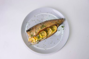 Limon dilimli fırında uskumru ve gri zemin üzerinde soğan. Taze dereotlu ızgara balık..