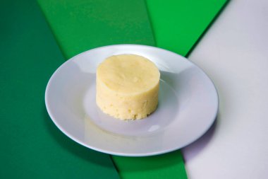 Mutfak halkasında servis edilen gri tabakta patates püresi. Restoran menüsü yeşil arka planda garnitür. Tek Sıcak Yan Yemek.