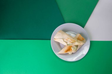 Geleneksel Gürcistan usulü lahanalı ekmek (pita) ve suluguni peyniri (yeşil otlar). piknik yemeği gri servis tabağında renkli arka planda.