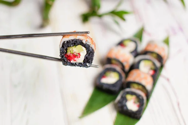Detail Sushi Roll Kus Černou Rýží Krevetami Vrcholu Kovových Hůlkách — Stock fotografie