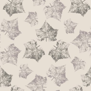 Seamless background from leaf prints of cucumber, brown imprints of plant leaves on a beige background.