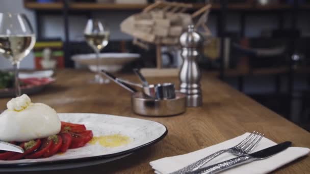 配上西红柿和罗勒的意大利面 餐厅的桌子上摆着一道漂亮的菜和一杯葡萄酒 餐厅提供的肉馅菜 精美的构图和一盘葡萄酒 — 图库视频影像