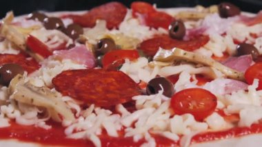 Yavaş çekimde kapari ile dekore edilmiş et pizza yakın. Yeşil kapari yukarıdan düşmek pizza Makro çekim. Bir İtalyan restoranında pizza pişirmek. Gıda video.