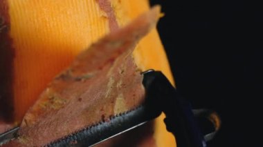 Birisi Batat soyuluyor. Biri tatlı patateslerden kabuğu kesiyor. Siyah bir arka planda tatlı patates makro çekim. Yakın çekim gıda video yavaş hareket.
