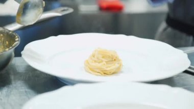 Mutfakta makarna yapan biri. Şef spagetti pişiriyor. Yemek videosu. Makarna hazırlama. Makarna tavada. gıda video