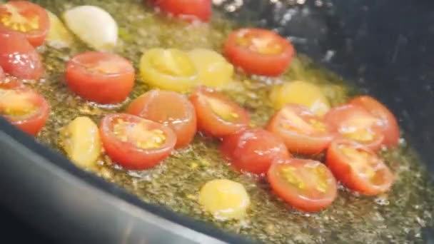 토마토는 프라이팬에 튀김입니다 요리사가 토마토를 튀기고 있습니다 누군가가 빨간색과 노란색 — 비디오