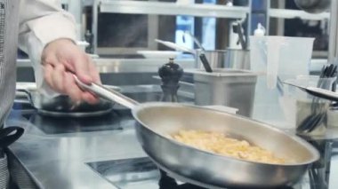 Makarna tavada pişiyor. Birisi makarna pişiriyor. Gıda video makro. Makarna hazırlama. İtalyan mutfağı.