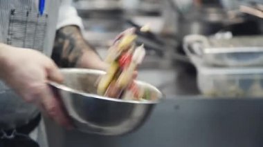 Deniz ürünleri ile sebze salatası. Salata yapma süreci. Eller karidesile salata hazırlıyor. Şef deniz ürünleri ile salata yapar ve restoranın mutfağında.