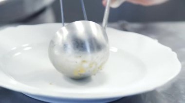Şef makarnayı tabağa koyuyor. Birisi İtalyan makarnası pişiriyor. Şef makarna yapıyor. Makarna tavada pişer. 