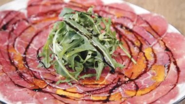 Rozetli ve balzamik soslu Carpaccio. Restorandaki güzel yemek. Restoranda güzel bir carpaccio servisi. Bir tabak carpaccio..