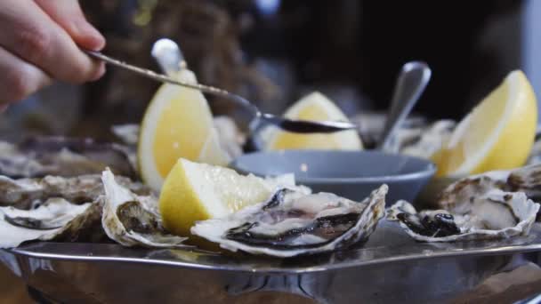 大きな牡蠣料理 魚屋で牡蠣を出す レモンとソースで氷の上の牡蠣 新鮮な牡蠣 — ストック動画